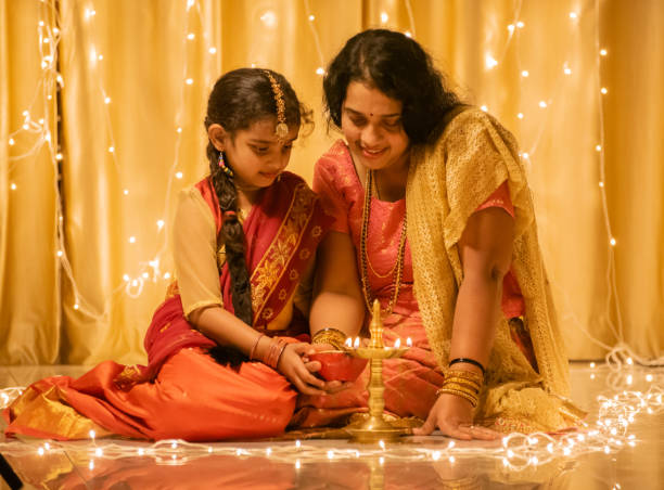 Beautiful young Indian girl aged 6 years and her mother holding Diwali lamp